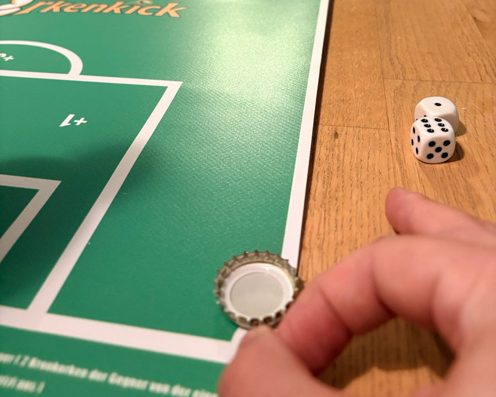 Finger schnippt einen Kronkorken, daneben zwei Würfel