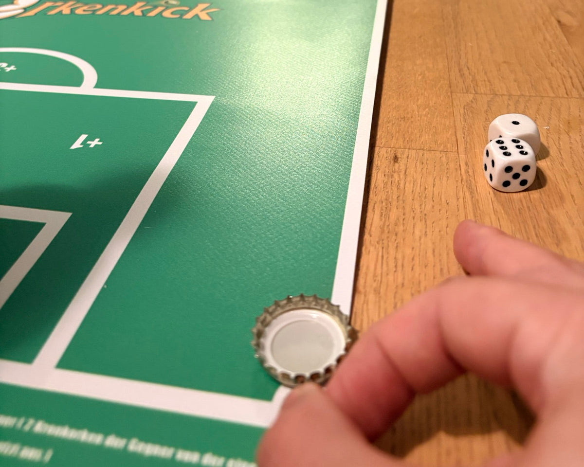 Finger schnippt einen Kronkorken, daneben zwei Würfel